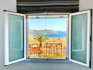 a room with a window with a view of the ocean at Sea view 4 bedrooms, 3 bathrooms Cottage in Anavyssos