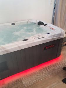a hot tub in a room with a red light at Instant secret in Pourrières