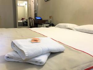 a white towel sitting on top of a bed at Hotel São Jorge São Paulo - By UP Hotel - próximo a 25 de março, fácil acesso ao Expo Center Norte e Mercado Municipal SP in São Paulo