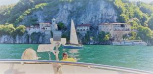 a man and woman on a boat in the water near a castle at Lush Lake Cruise with Boat & Breakfast in Lesa