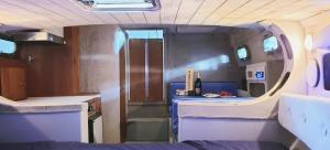 a small room with a bed and a small kitchen at Lush Lake Cruise with Boat & Breakfast in Lesa
