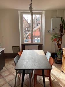 un tavolo da pranzo con sedie e una finestra di Il Piano Nobile a Colmar