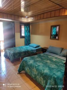 a bedroom with two beds in a room at Hostal Boquete in Boquete