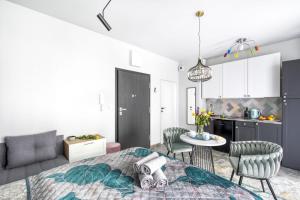 een woonkamer met een bed en een keuken bij Apartamenty MetroPark Krzemieniecka-Lux in Warschau