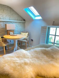 een slaapkamer met een bed en een tafel met een tapijt bij The Loft in the Malt Barn Chipping Campden in Mickleton
