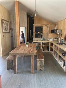 ein großer Holztisch in einem Raum mit Küche in der Unterkunft CASA VISTA CORRAL in Malalcahuello