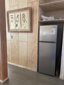 einen Kühlschrank in einer Küche mit einem Schreiben an der Wand in der Unterkunft CASA VISTA CORRAL in Malalcahuello