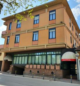 a large building with windows on a street at HOTEL PERLA in Massa Lombarda