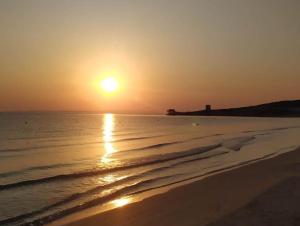 a sunset on the beach with the sun setting at Villaggio San Pablo in Vieste