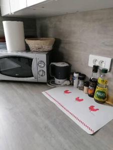 a kitchen with a microwave and a table with spices at Appartement de vacances au 1er étage 45m2 in Antibes