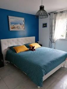 een blauwe slaapkamer met een bed met een teddybeer erop bij Appartement de vacances au 1er étage 45m2 in Antibes