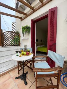 a patio with a table and two chairs and a window at Naxos Philoxenia in Naxos Chora