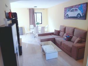 sala de estar con sofá marrón y mesa en Ryaproperty, en Morro del Jable