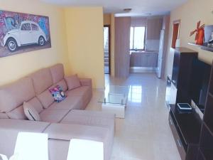 sala de estar con sofá y TV de pantalla plana en Ryaproperty, en Morro del Jable