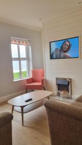 a living room with a couch and a fire place at Inch Beach Cottages in Inch