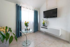 een woonkamer met een tv en een tafel bij Apartman MatLuk1 in Dubrovnik