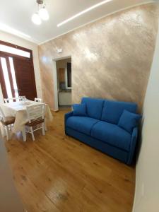 a living room with a blue couch and a table at Casa vacanze - "O Tunnu" in Avola