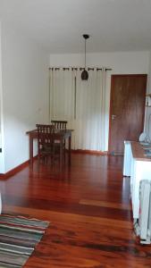 uma sala de estar com uma mesa e um piso de madeira em Hospedaria Caminho da Roça em Gonçalves