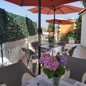 einen Tisch mit lila Blumen in einer Vase auf einer Terrasse in der Unterkunft Kuća Anka in Herceg-Novi