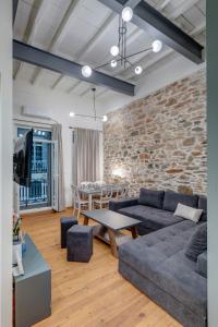 a living room with a couch and a brick wall at The Heart of Syra - Your Home in Ermoupolis in Ermoupoli