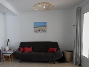 a living room with a couch and a picture of a beach at Maison au coeur de Meschers - proche des plages in Meschers-sur-Gironde