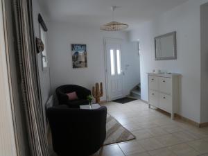 a living room with a chair and a table at Maison au coeur de Meschers - proche des plages in Meschers-sur-Gironde