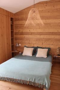a bedroom with a bed with a wooden wall at Lodge Les Oliviers in Garéoult