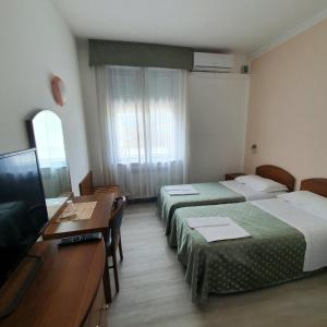 a hotel room with two beds and a flat screen tv at HOTEL PERLA in Massa Lombarda +96 photos