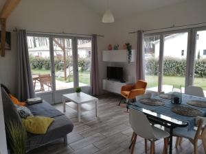 a living room with a couch and a table at Maison moderne proche lac et plage in Léon