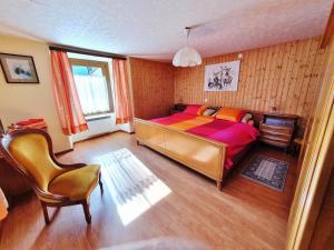 1 dormitorio con 1 cama y 1 silla en BnB "A la Crus", en Crana