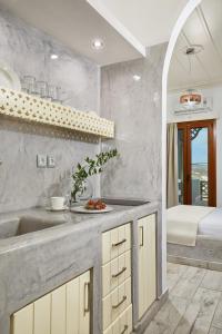 a kitchen with a sink and a bathroom with a tub at Agnadi studios in Maltezana
