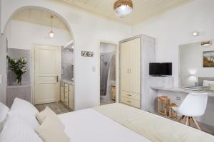 a white bedroom with a bed and a bathroom at Agnadi studios in Maltezana