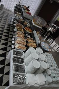 a buffet with plates and other food on a table at Hotel Metrópole Maringá in Maringá