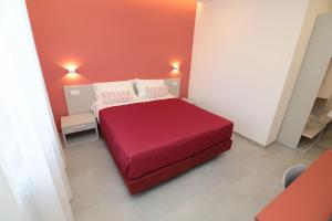 ein Schlafzimmer mit einem roten Bett in einem Zimmer in der Unterkunft Maison Nanà in Sorrent