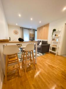 a kitchen and living room with a table and two stools at Cozy 2 pièces AUX PORTES DE PARIS ! in Issy-les-Moulineaux +8 photos