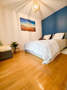 - une chambre avec un lit et un mur bleu dans l'établissement Cozy 2 pièces AUX PORTES DE PARIS !, à Issy-les-Moulineaux