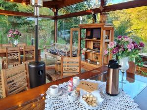 uma sala de jantar com uma mesa com comida e flores em Pousada Chico Anjo em Ouro Preto