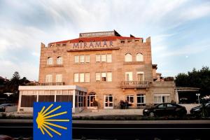 a large brick building with a sign in front of it at Hotel Miramar Playa America Nigran in Nigrán