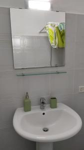 La salle de bains est pourvue d'un lavabo blanc et d'un miroir. dans l'établissement Il Piccolo Loft, à Carovigno