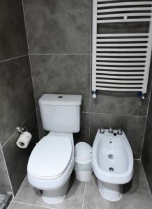 a bathroom with a white toilet and a sink at Departamento Calchines con cochera in Santa Fe +13 photos