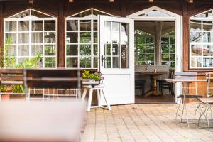 a conservatory with a door and tables and chairs at Elbterrasse Wörlitz in Oranienbaum-Wörlitz