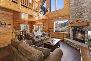 a living room with couches and a fireplace in a cabin at 004 - Bearadise in Big Bear Lake