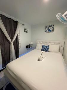 a bedroom with a large white bed and a window at Blue Royalty in Portmore