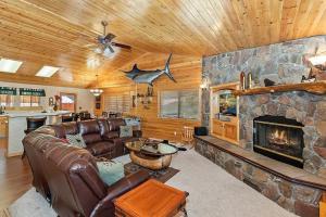uma sala de estar com um sofá e uma lareira de pedra em 007 - The Log Cabin Getaway em Big Bear City