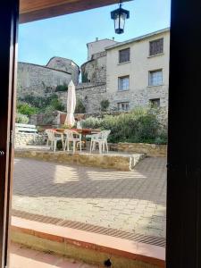 un patio con mesa y sillas y un edificio en Les Ecuries, traditional stone farmhouse with pool en Marquixanes