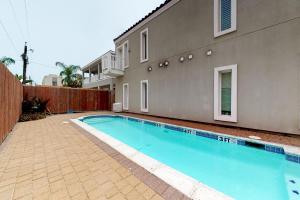 a swimming pool in front of a building at Kingfisher in South Padre Island