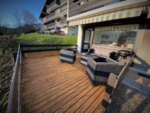 une terrasse en bois avec deux chaises et un grill dans l'établissement Studio 20m2 Avec Terrasse 16m2 Vue sur la Vallée, à Habère-Poche