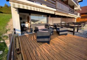 una terrazza con sedie e tavoli su una casa di Studio 20m2 Avec Terrasse 16m2 Vue sur la Vallée a Habère-Poche