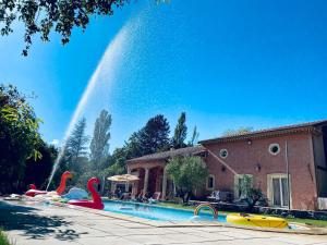 een zwembad met opblaasbare flamingo's en een fontein bij Le Loft Occitanie Sud de France in Ceilhes-et-Rocozels