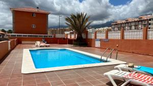 a swimming pool on the roof of a building at Candelaria playa TENERIFE in Candelaria
